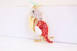 Détail d'un porte-clés pélican avec strass et ailes en émail rouge sur base dorée