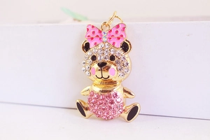 Macro shot of a cute golden bear keychain with rhinestones and pink polka dot bow