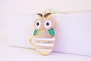 Detailed close-up of a creative owl keychain with rhinestones and green enamel wings