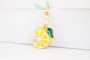 Detail showing a yellow lemon slice pendant with sparkling rhinestones and a gold metal clip