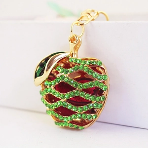 Golden apple keychain pendant featuring intricate hollow design and green crystal rhinestones