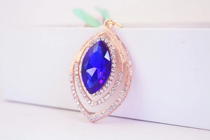 Macro detail of eye-shaped pendant with deep blue crystal and sparkling diamond inlay