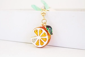 Detail of creative orange slice keychain with sparkling rhinestones and enamel finish