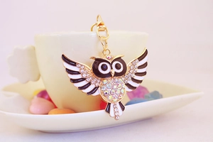 Eulenschlüsselanhänger mit Kristallen an weißer Tasse und Herzschale mit bunten Bonbons
