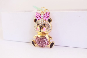 Macro detail of cartoon bear keychain with purple crystals and pink bow decoration