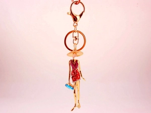Detailed view of fashion lady keychain with red crystal dress and blue handbag charm