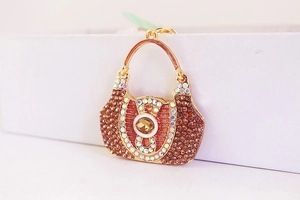 Macro detail of crystal handbag keychain with brown rhinestones and gold plating