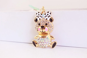 Detailed close-up of a gold-plated bear keychain featuring sparkling AB crystals and a polka dot bow