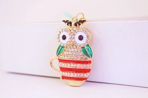 Close-up of owl teacup keychain with sparkling rhinestones and golden enamel finish