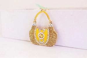 Detail of golden handbag keychain charm encrusted with yellow rhinestones and crystals