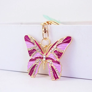 Golden butterfly keychain with purple enamel wings and sparkling rhinestones for bags