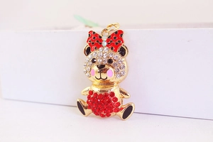Macro shot of cute teddy bear pendant with red crystals and black polka dot bow tie