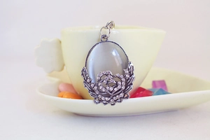 Detailed macro of vintage silver peony keychain featuring grey cat eye stone and tiny crystals