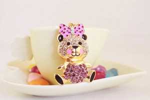 Detailed macro of golden bear keychain with pink bow and sparkling crystal stones