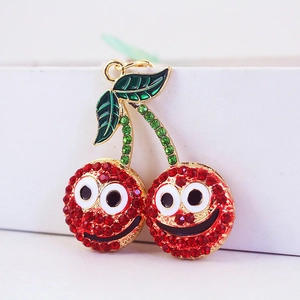 Porte-clés cerise avec strass rouges et grands yeux sur un anneau doré élégant