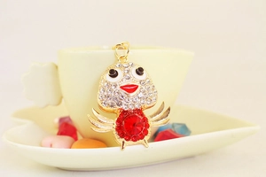 Close-up of cute chicken keychain with red crystal gemstone and sparkling rhinestones