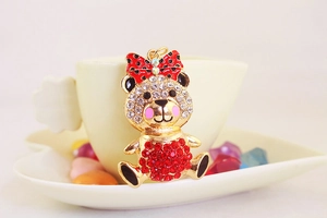 Close-up of golden bear keychain with rhinestones and a red polka dot bow decoration