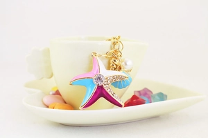 Dettaglio del portachiavi a stella marina colorata con perle e cristalli su una tazza
