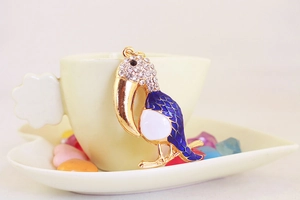 Détail du porte-clés toucan avec strass et texture en émail bleu élégant