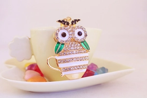 Detailed view of owl coffee cup keychain with rhinestones and green enamel accents