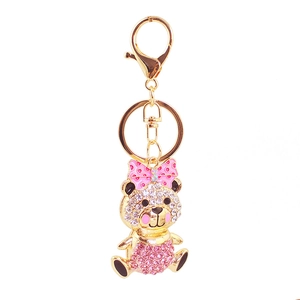 Close-up of golden bear keychain with sparkling pink and white rhinestones and a polka dot bow