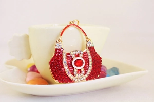 Close-up of golden handbag charm with sparkling red and AB rhinestones for keychains