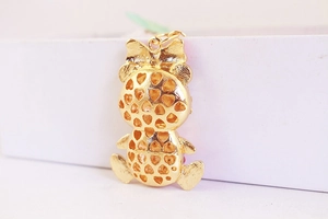Detailed back view of gold bear keychain with hollow heart pattern and bow decoration