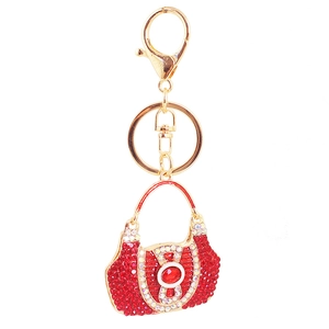 Detailed macro view of creative handbag keychain with red crystals and gold-tone clasp