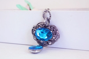 Vue détaillée du médaillon vintage en argent avec cristal bleu et strass brillants