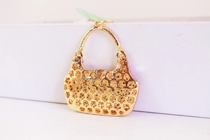 Macro detail of a gold hollow floral handbag charm pendant for keychains