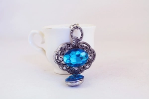 Détail du pendentif en argent vintage avec gemme bleue et gravures évidées complexes