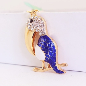 Porte-clés toucan doré chic avec strass blancs étincelants et détails en émail bleu ciel