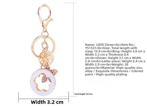 Detail view of gold clover keychain with inlaid rhinestones and white enamel finish