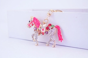 Detail of horse-shaped keychain with sparkling crystals and pink enamel mane