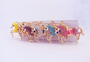 Macro view of colorful rhinestone flying horse keychains with gold metal plating