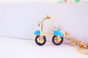 Détail du porte-clés scooter créatif en alliage doré avec émail bleu et strass brillants