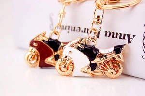 Dettaglio portachiavi a forma di moto con strass bianchi e bordeaux con finitura oro
