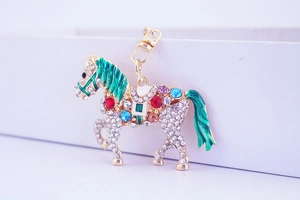 Detail of crystal-encrusted horse keychain with emerald green enamel and colorful gems