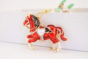 Dettaglio del portachiavi a forma di cavallo in smalto rosso con cristalli e metallo dorato