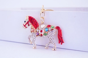 Close-up of sparkling rhinestone horse keychain with red enamel and colorful gems