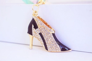 Macro view of high-heel keychain with golden alloy, black enamel, and sparkling rhinestones