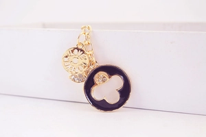 Detailed close-up of golden four-leaf clover keychain with Love Forever engraving