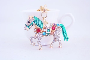 Detailed close-up of a sparkling rhinestone horse keychain with green enamel mane accents