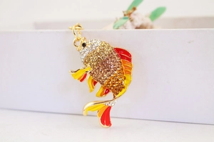 Nahaufnahme vom goldenen Koi-Anhänger mit glitzernden Strasssteinen und bunter Emaille