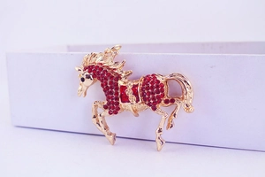 Detailed macro view of the golden horse keychain pendant with red crystal rhinestones