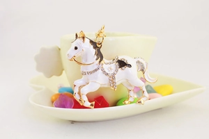 Vista dettagliata del ciondolo a cavallo in smalto bianco con strass e finiture in oro