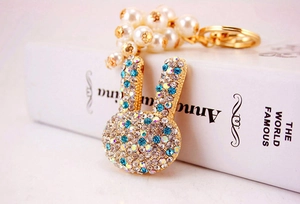 Détail d'un porte-clés lapin mignon avec strass bleus et perles fantaisie blanches