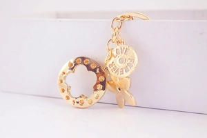 Macro detail of golden lucky clover keychain with Love Forever engraved metal pendant charm