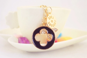 Detail of gold keychain with black enamel clover charm and Love Forever engraving