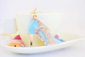 Detailed view of light blue enamel high heel charm with sparkling crystals on gold metal